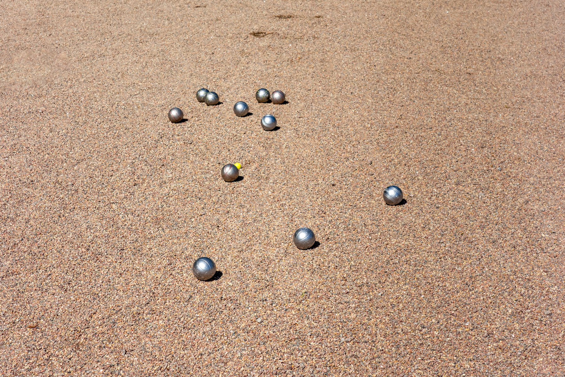 Boules de pétanque posées sur un terrain de gravier